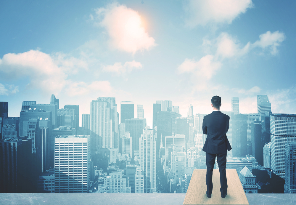 Businessman standing on a roof and looking at future city